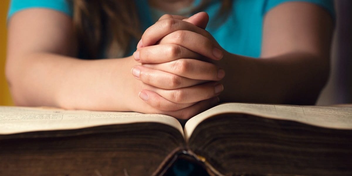 33418-praying-over-bible-1200.1200w.tn